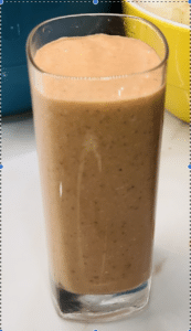 Glass of smoothie with frothy texture.